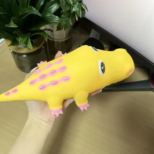 Primer plano detallado de un juguete squishy cocodrilo amarillo de rebote lento para el estrés