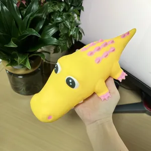 Primer plano de un juguete blandito de cocodrilo amarillo de crecimiento lento en la mano