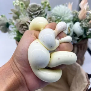 Dettaglio di una mano che preme un morbido giocattolo antistress a forma di patata gialla.