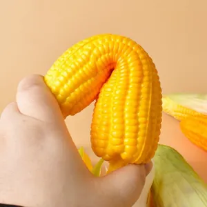 Hand squeezing a realistic yellow corn squishy toy to show its flexibility