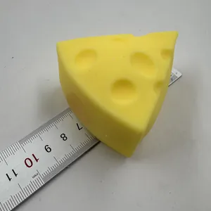 Detailansicht eines gelben Käse-Knautschspielzeugs neben einem Lineal zur Größenbestimmung