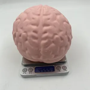 Detailed view of realistic pink brain-shaped stress relief squishy toy being weighed on a digital scale