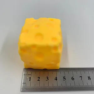 Vue détaillée d'un jouet squishy fromage jaune à côté d'une règle en métal pour l'échelle