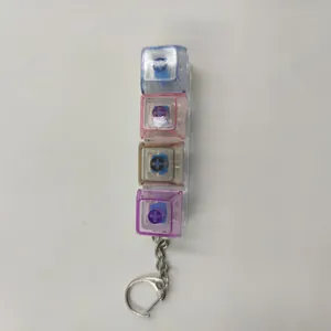 Détail vertical d'un porte-clés fidget à 4 touches mécaniques transparentes.