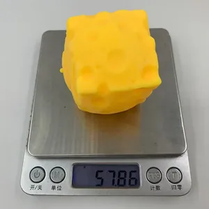 Gros plan d'un jouet anti-stress fromage pesant 57,86 g sur une balance numérique