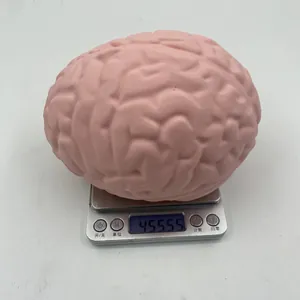 Detailed view of pink anatomical brain stress ball being weighed on a digital scale