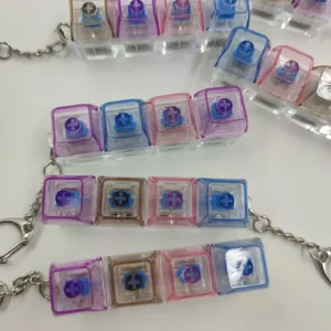 Vue détaillée des porte-clés fidget à 4 touches mécaniques avec boîtiers transparents