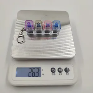 Gros plan d'un porte-clés mécanique à 4 touches pesant 26,3 g sur une balance de précision.