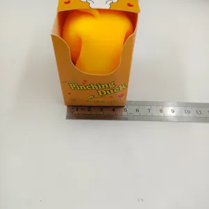 Gelbes Enten-Stressspielzeug in der Verpackung, mit einem Metalllineal für die Größe.