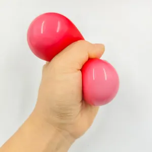 Close-up of a hand squeezing a red heart-shaped squishy toy for stress relief