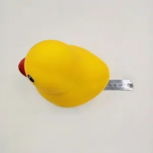 Primer plano de un juguete antiestrés de pato amarillo con regla para mostrar el tamaño