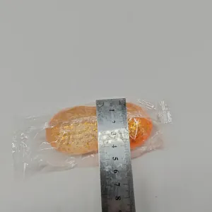 Close-up of glittery peanut squishy toy being measured with a metal ruler