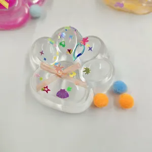Macro view of a clear cat paw squishy toy filled with colorful sequins and heart shapes