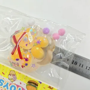 Detailed macro shot of yellow cat paw squishy with sequins in clear packaging bag