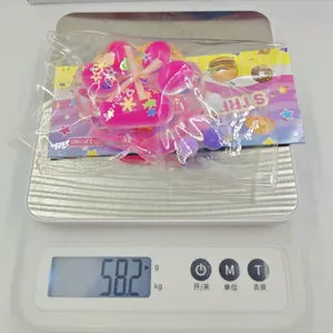 Pink cat paw squishy toy weighing 58.2g on a digital scale for daily stress relief
