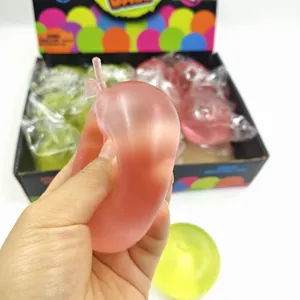 Nahaufnahme einer Hand, die ein rosa malzgefülltes Apfel-Antistress-Spielzeug drückt