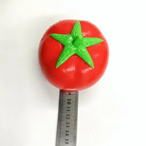 Detailed top view of a red simulation tomato squishy toy next to a ruler for size