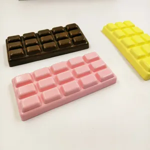 Dettaglio di tre giocattoli squishy a forma di cioccolato in marrone, rosa e giallo.