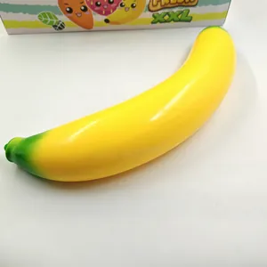 Close-up of a large yellow TPR simulation banana stress relief squishy toy on white