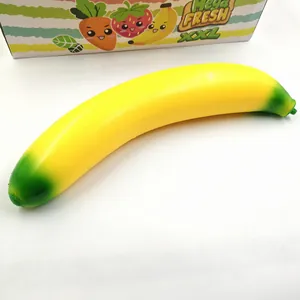 Close-up view of a large yellow banana squishy stress relief toy on a white background