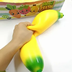 Close-up of a hand squeezing a large yellow banana-shaped TPR squishy stress relief toy