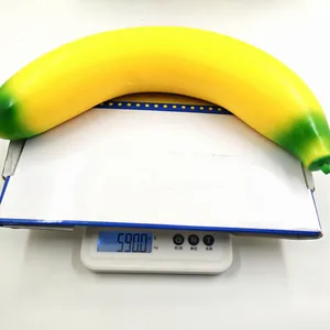 Detail view of a 590g large TPR simulation banana squeeze toy on a scale.