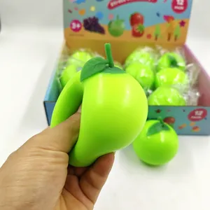 Macro view of a hand squeezing a green apple stress relief toy for texture detail