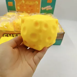 Dettaglio di un morbido cubo di formaggio giallo giocattolo antistress tenuto in mano