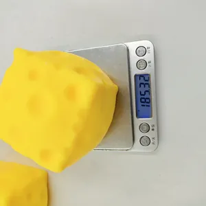 Dettaglio che mostra il peso di 185,32g di un giocattolo antistress a forma di formaggio.