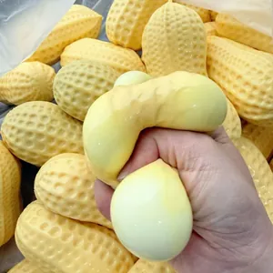 Dettaglio di una mano che preme un grande giocattolo antistress a forma di arachide.