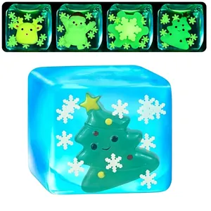 Luminous Christmas squishy toy in clear ice cube shape with glowing tree and snowflakes