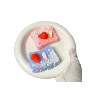 Vue détaillée de mignons jouets squishy toast à la fraise roses et bleus sur une assiette