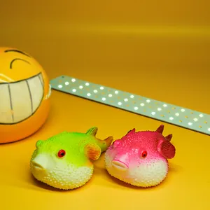 Close-up view of realistic green and pink pufferfish squishy toys for stress relief