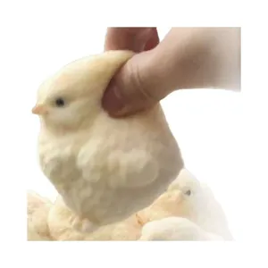Hand drückt ein weiches gelbes Küken-Squishy-Spielzeug für den Stressabbau und die Entspannung