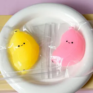 Gros plan de jouets antistress en forme de banane jaune et rose sur une assiette blanche