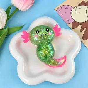 Nahaufnahme des grünen Glitzer-Axolotl-Quetschspielzeugs mit schimmernden Pailletten