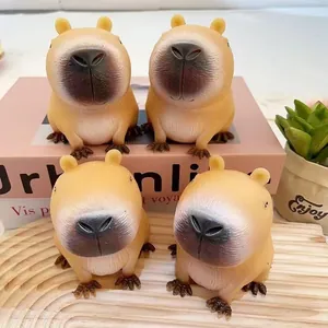 Quatre mignons jouets à presser capybara sur plateau en bois et boîte rose déco
