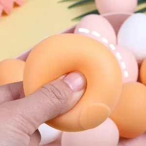Close-up view of hand squeezing a soft egg-shaped squishy toy for stress relief
