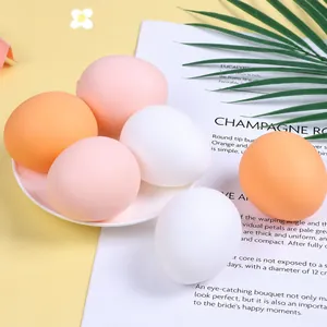 Detailed view of multiple colorful simulation egg squeeze stress toys on a white plate.