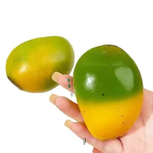 Κοντινό πλάνο παιχνιδιού squishy σε σχήμα μάνγκο με εφέ αλλαγής χρώματος στο χέρι