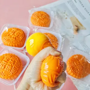 Close-up of hand squeezing a realistic mooncake squishy toy showing elasticity