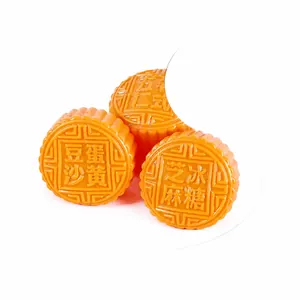 Close-up of realistic orange mooncake squishy toy on a white plate