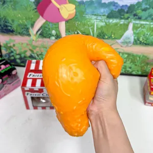 Detailed view of a hand squeezing a jumbo simulation fried chicken leg squishy toy