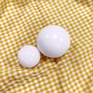 Close-up of white TPR slow rebound decompression balls placed on yellow plaid fabric