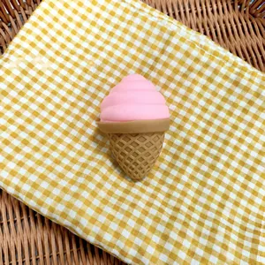 Detail shot of a pink ice cream squishy toy on a yellow checkered cloth background