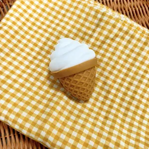 Detalle de un juguete squishy con forma de helado sobre una tela de cuadros amarilla