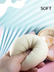 Detailed close-up of soft silicone bun squishy toy being squeezed for stress relief