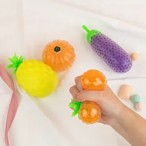 Set of fruit and vegetable stress relief squeeze balls on white fabric background