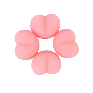 Close-up of four pink peach-shaped squishy stress relief toys on a white background.