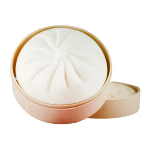 Realistic steamed bun squishy stress relief toy in a simulation bamboo steamer